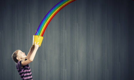 Cute girl with bucket and colorful springs coming outの写真素材