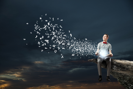 Young man student sitting with book in handsの写真素材