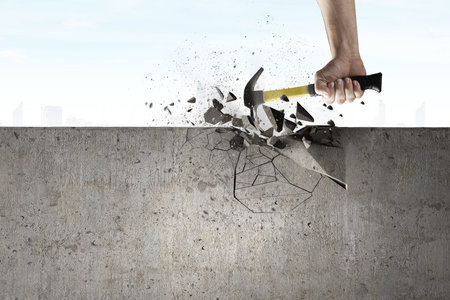 Close up of hammer in hand breaking cement wallの写真素材