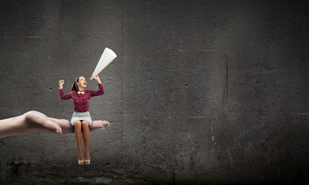 Young pretty woman screaming in paper trumpetの写真素材