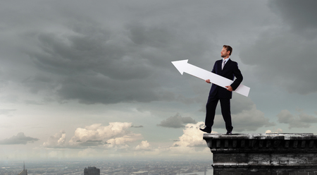 Businessman in suit with white blank arrow in handsの写真素材