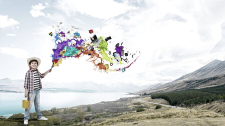 Boy of school age with yellow bucket and paint brushの写真素材