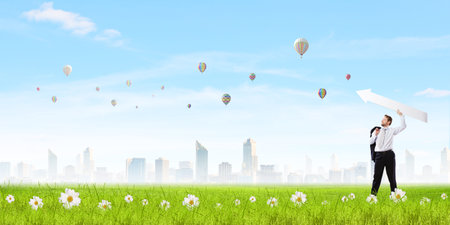 Businessman in suit with white blank arrow in handsの写真素材