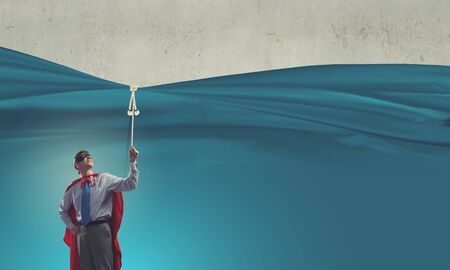 Young confident super guy in mask and capeの写真素材