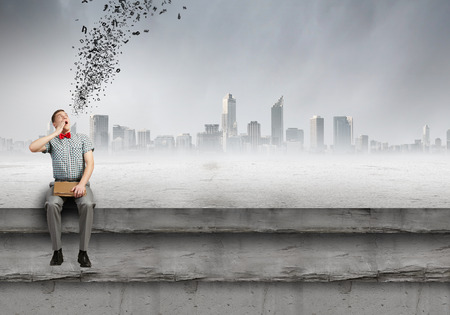 Young man student sitting with book in handsの写真素材