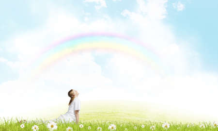 Young smiling girl doing yoga elements on grassの写真素材