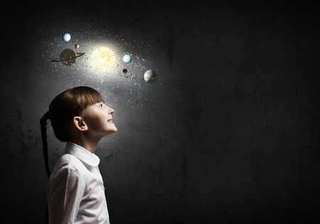 Cute girl of school age exploring space systemの写真素材