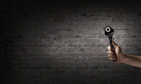 Close up of hand spinning nut with wrenchの写真素材