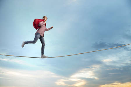 Young running girl with red santa bag in handsの写真素材