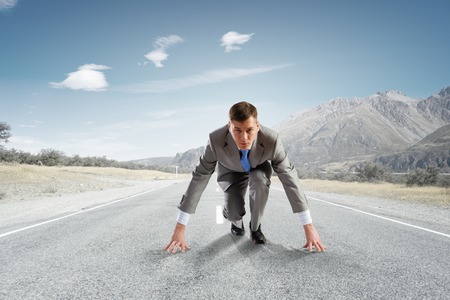 Young determined businessman standing in start positionの写真素材