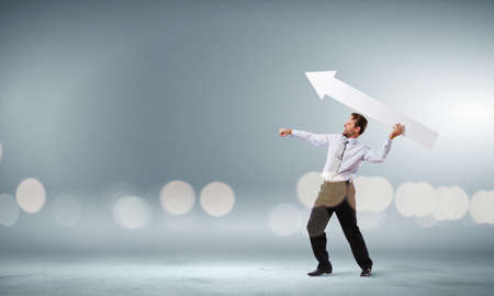 Businessman in suit with white blank arrow in handsの写真素材