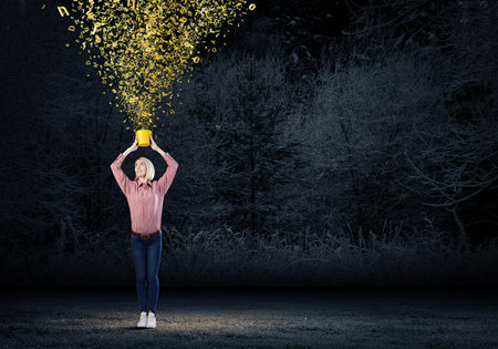 Young blond woman with yellow bucket in hands