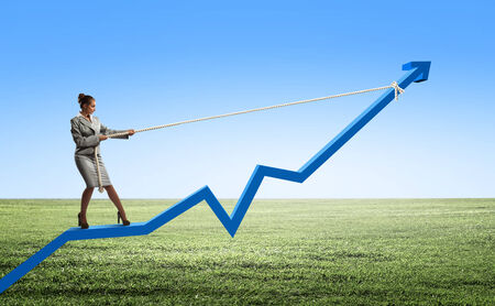 Businesswoman pulling arrow with rope and making it raise upの写真素材