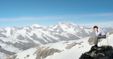 Troubled businessman sitting in chair on top of mountainの写真素材