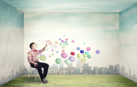 Young funny teenager guy sitting in chairの写真素材