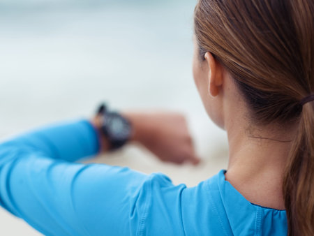 Sporty young woman looking at her watchesの写真素材