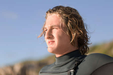 A surfer with his surfboard at the beachの写真素材