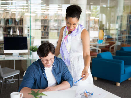 Shot of a young office worker getting some assistance from his managerの写真素材