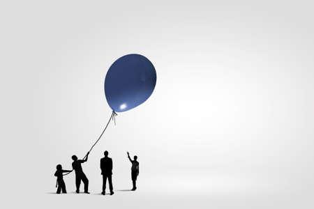 Little silhouettes of people pulling rope with balloonの写真素材