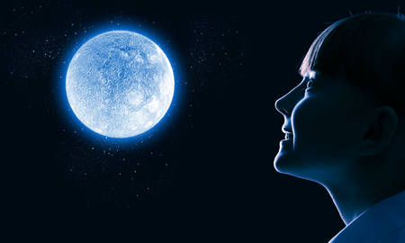 Cute girl of school age against night backgroundの写真素材