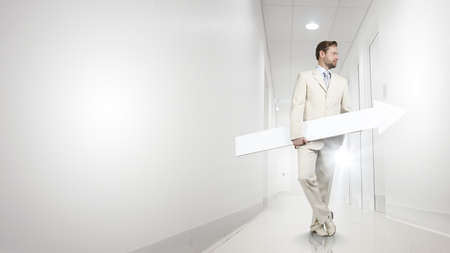 Businessman in suit with white blank arrow in handsの写真素材