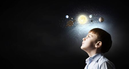 Cute boy of school age exploring space systemの写真素材