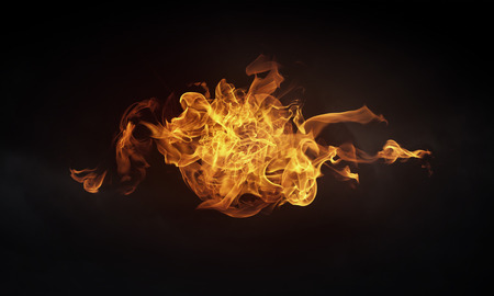Conceptual image of burning fire on dark backgroundの写真素材