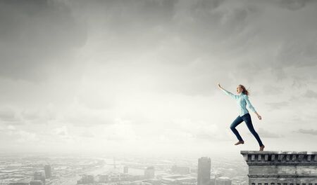 Young girl on edge making step above gapの写真素材