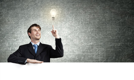 Young businessman holding white blank banner. Place for textの写真素材