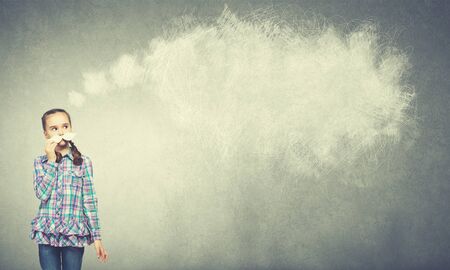 Funny cute girl trying on paper mustacheの写真素材