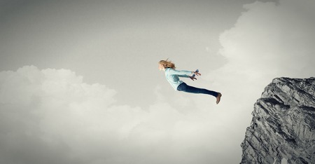 Young girl on edge making step above gapの写真素材