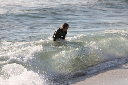 A surfer with his surfboard at the beachの写真素材