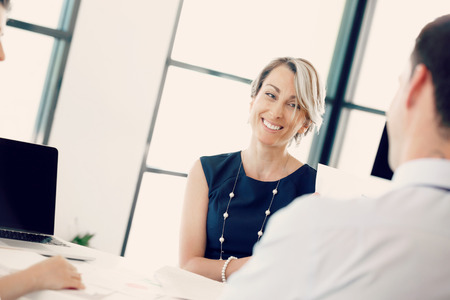 Female manager assessing work of her employeesの写真素材
