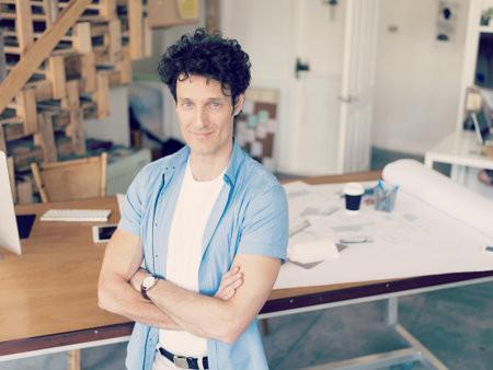 Man standing next to his desk in office