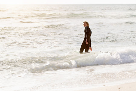 A surfer with his surfboard at the beach