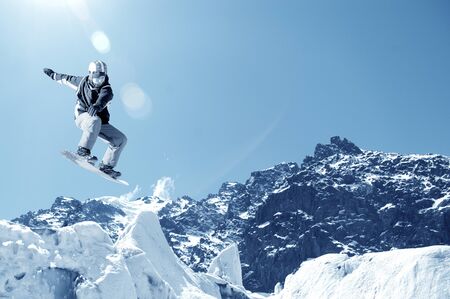 Snowboarder making jump high in clear skyの写真素材