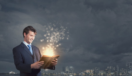 Handsome young man in suit with book in hands