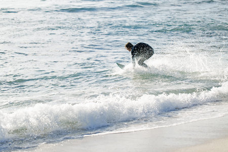A surfer with his surfboard at the beach
