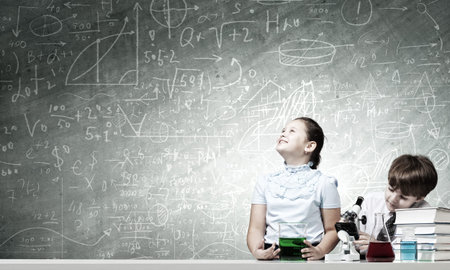 Two cute children at chemistry lesson making experiments
