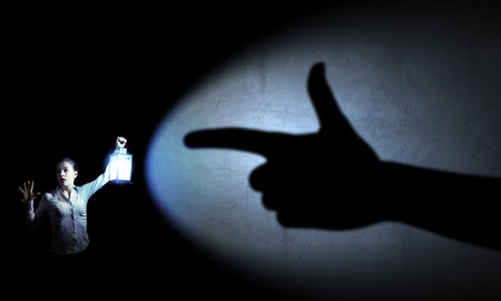 Young pretty businesswoman with lantern in darkness
