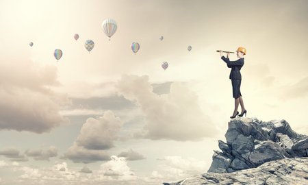 Young woman engineer looking in to spyglassの写真素材