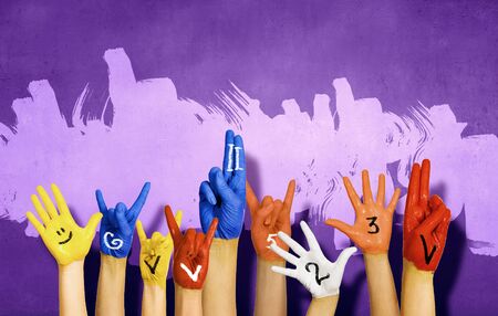 Human hands in colorful paint showing symbolsの写真素材