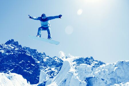 Snowboarder making jump high in clear skyの写真素材