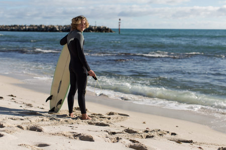 A surfer with his surfboard at the beachの写真素材