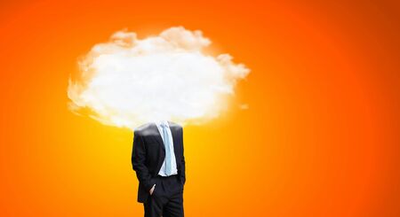 Businessman standing with his head in cloudの写真素材