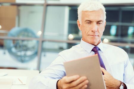 Businessman standing in office smiling at cameraの写真素材