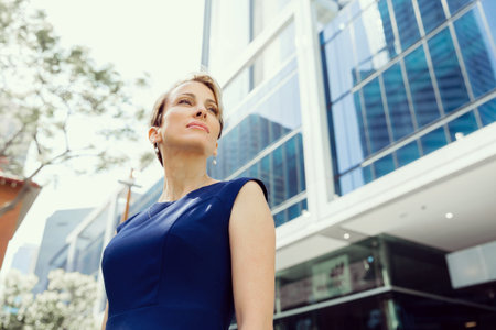Businesswoman standing next to her office in the morningの写真素材