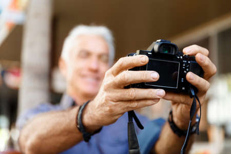 Senior man with camera in cityの写真素材