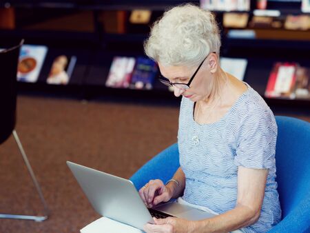 Elderly lady working with laptopの写真素材