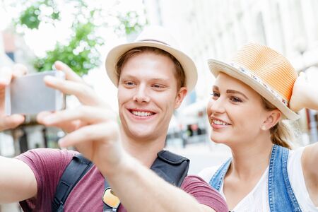 Happy young couple as tourists with a cameraの写真素材